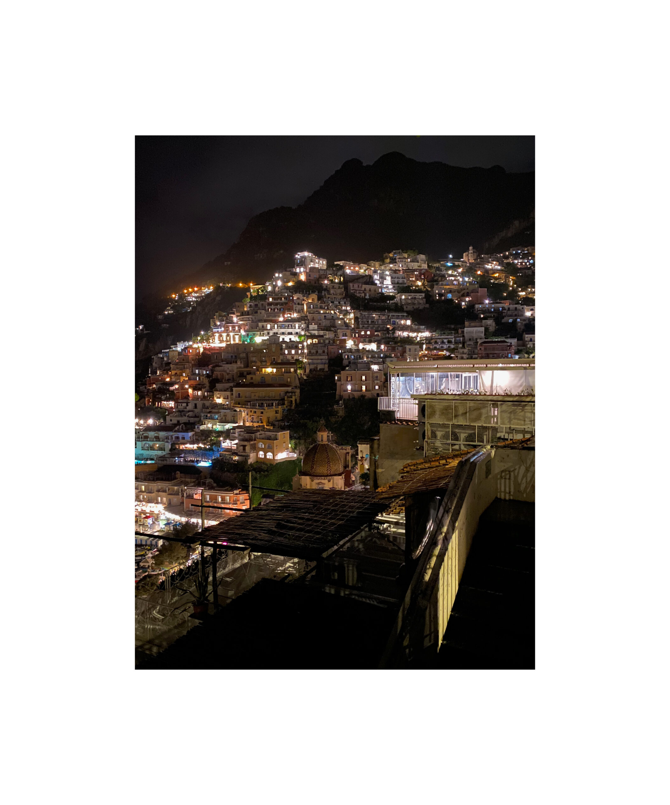 The town of Positano in Italy lit up at night.